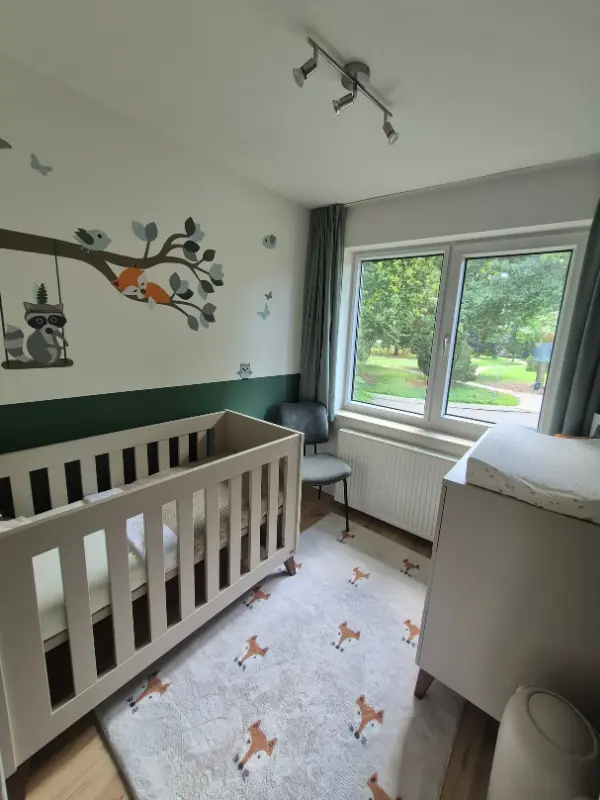 Bosdieren behangsticker in een groene babykamer.